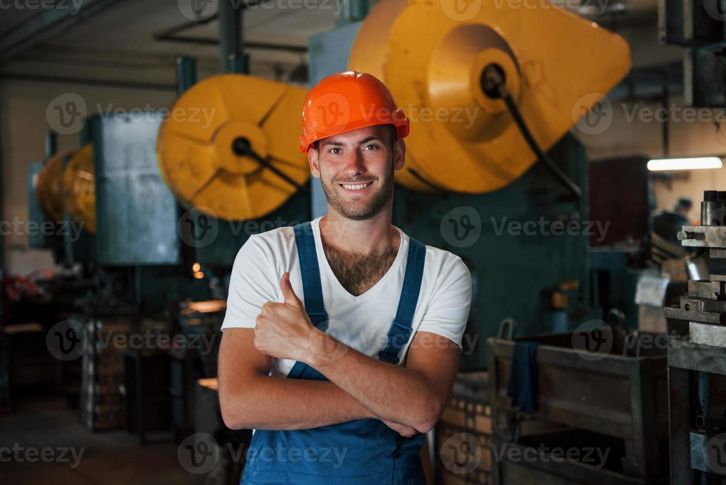 positiv kille. porträtt av ingenjör i metallurgisk fabrik i skyddande hjälm foto