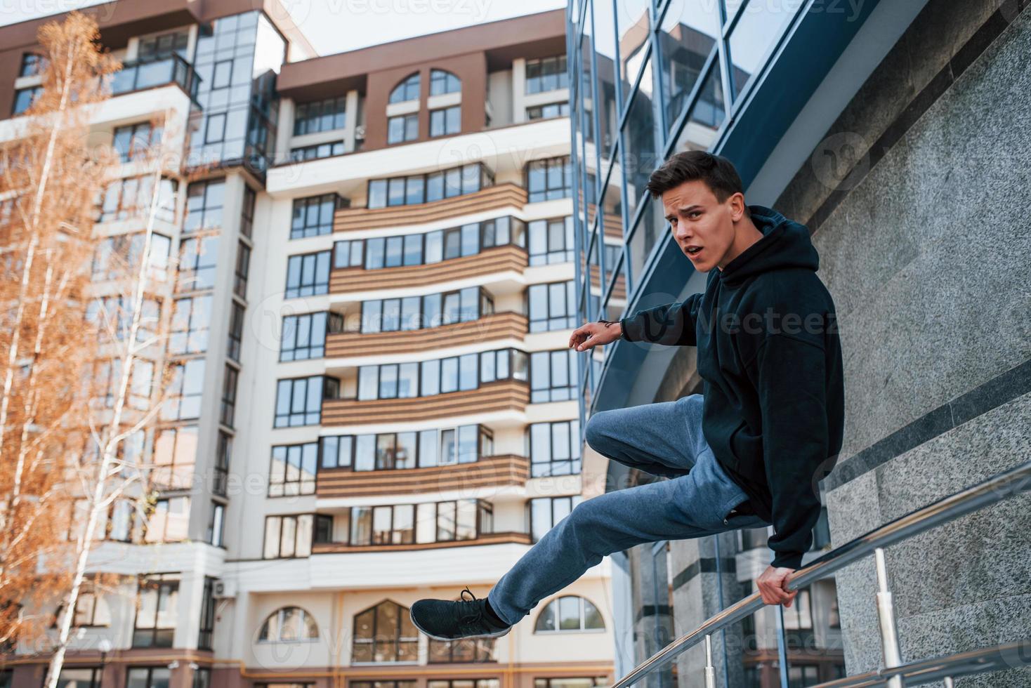 ung man håller på med parkour i de stad på dagtid. uppfattning av extrem sporter foto