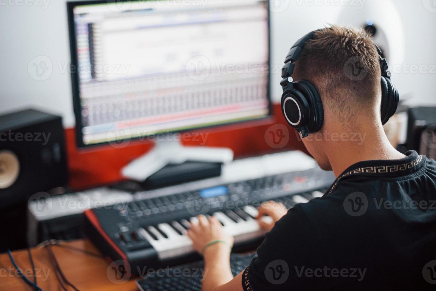 ljud ingenjör i hörlurar arbetssätt och blandning musik inomhus i de studio foto