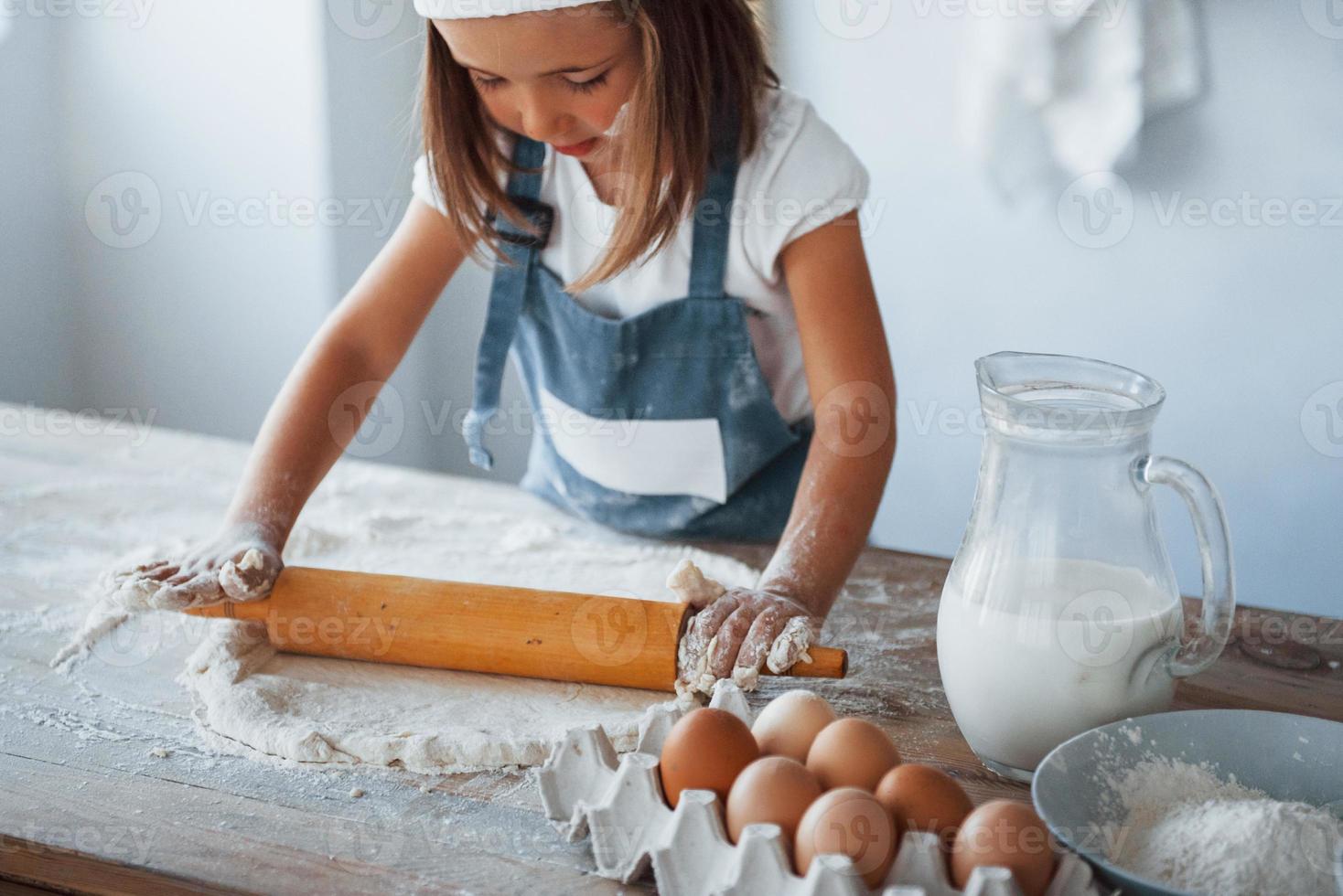 söt unge i vit kock enhetlig framställning mat på de kök foto