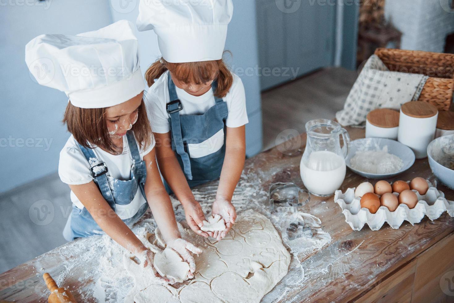 koncentrering på matlagning. familj barn i vit kock enhetlig framställning mat på de kök foto