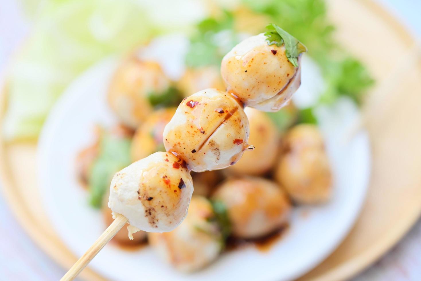 köttbullar på tallrik med med kryddad sås, grillad köttbulle och fläsk boll, kött boll på grillspett och färsk koriander grönsaker kål, thai mat asiatisk mat kött bollar - fläsk bollar foto