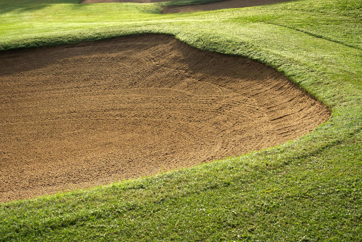 sandlåda bunkra golf kurs bakgrunder, de sandlåda på de golf kurs fairway är Begagnade som en hinder för idrottare till konkurrera foto