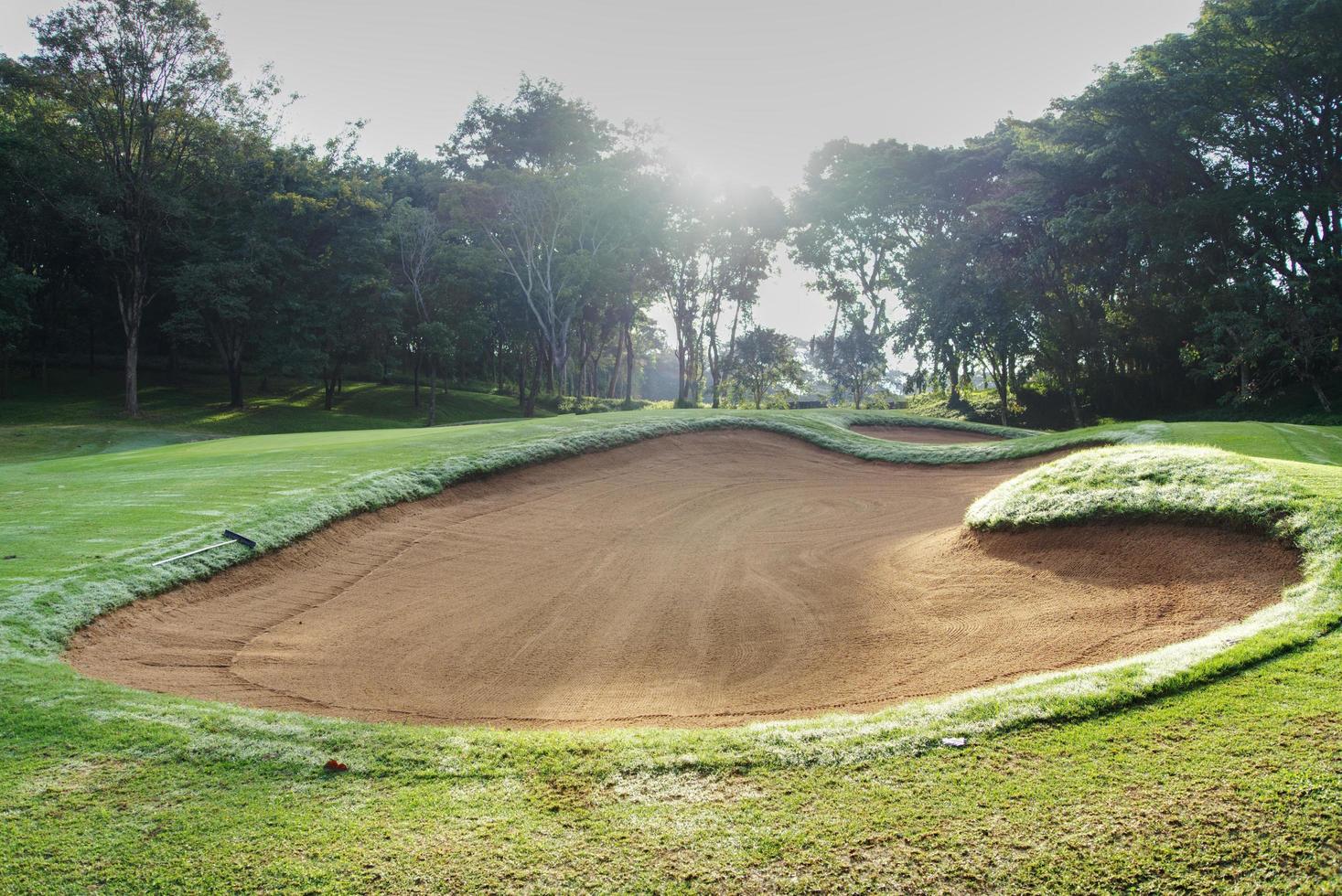 sandlåda bunkra golf kurs bakgrunder, de sandlåda på de golf kurs fairway är Begagnade som en hinder för idrottare till konkurrera foto