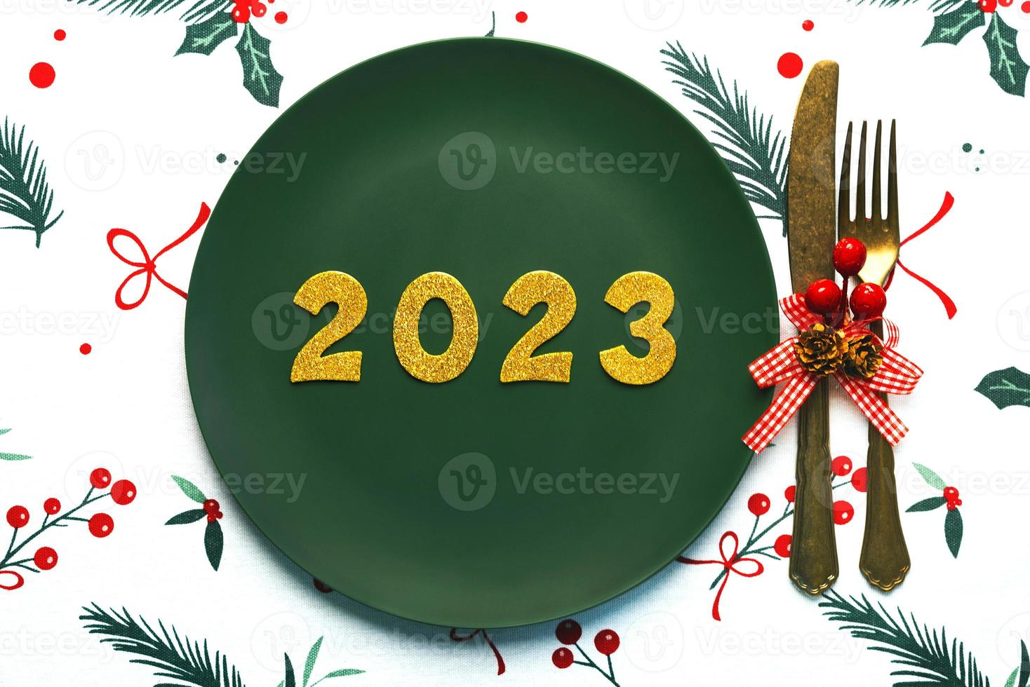 Lycklig ny år 2023. topp se av gyllene tal 2023 på tallrik med bestick för jul middag. ny år eve firande begrepp bakgrund foto