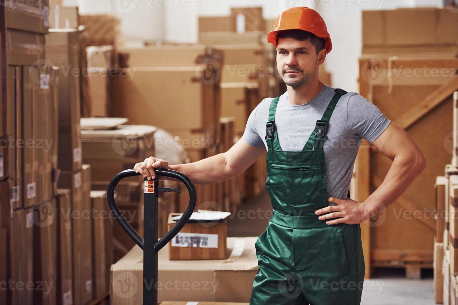 ung manlig arbetstagare i enhetlig är i de lager med lastpall lastbil foto