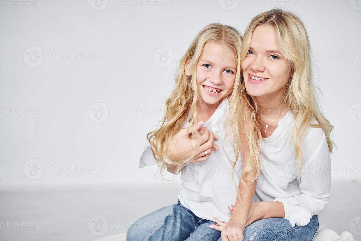 närhet av de människor. mor med henne dotter tillsammans i de studio med vit bakgrund foto