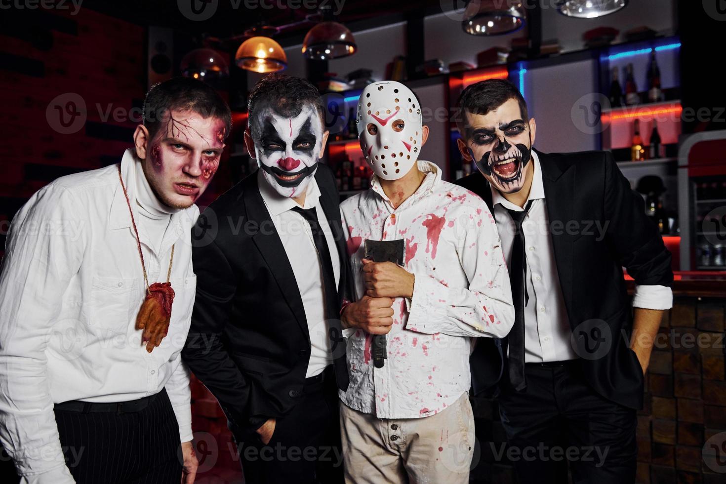 vänner är på de tematiska halloween fest i skrämmande smink och kostymer foto