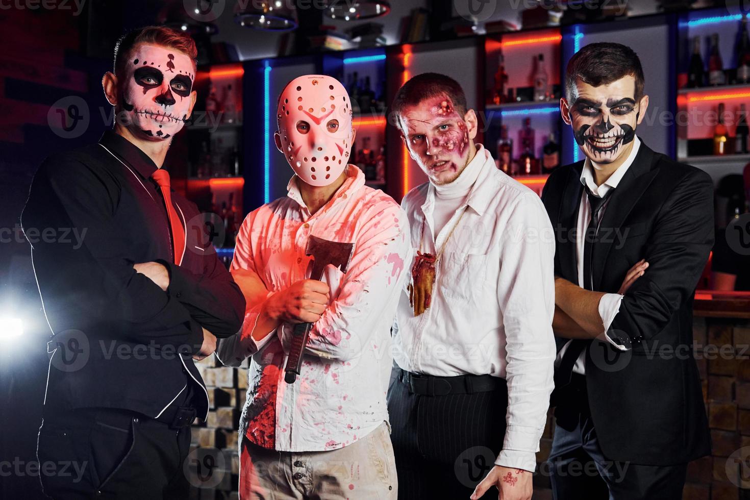 Framställ för de kamera. vänner är på de tematiska halloween fest i skrämmande smink och kostymer foto