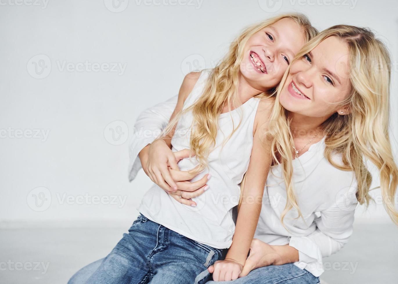 närhet av de människor. mor med henne dotter tillsammans i de studio med vit bakgrund foto