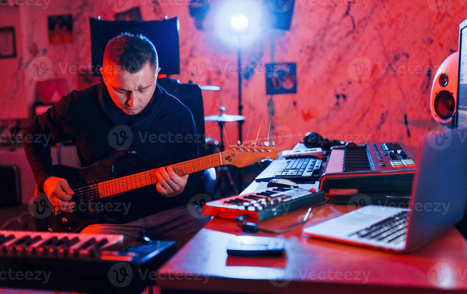 gitarr spelare ha inspelning session inomhus i de studio foto