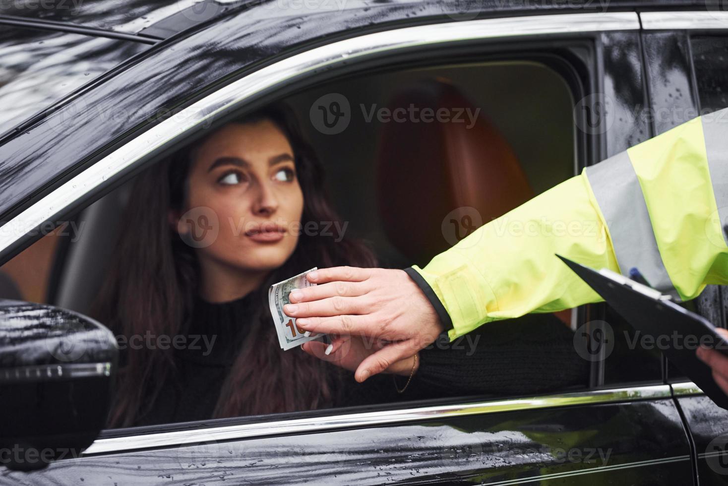 manlig polis officer i grön enhetlig vägra till ta muta från kvinna i fordon foto