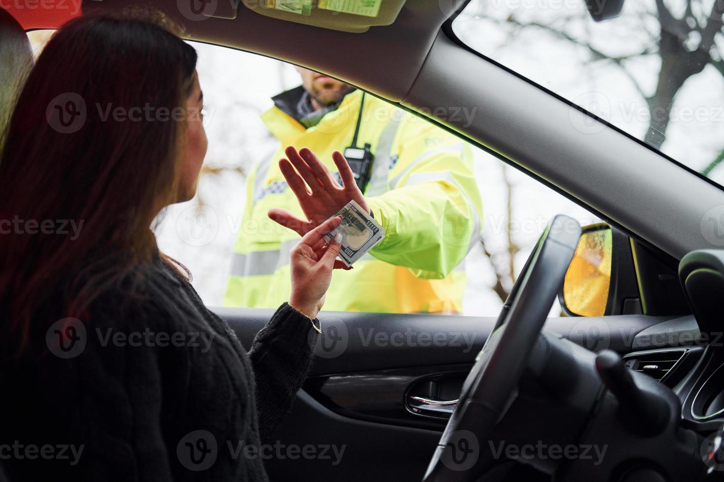 manlig polis officer i grön enhetlig vägra till ta muta från kvinna i fordon foto