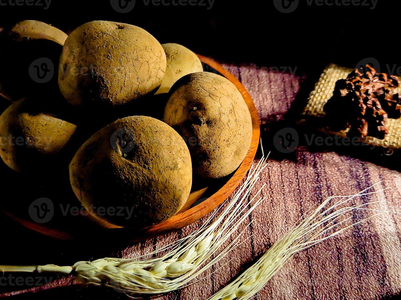 lugg av rå potatisar på mörk trä- bakgrund. förberedelse av potatis soppa eller maträtt, perfekt för reklam broschyr bakgrund foto