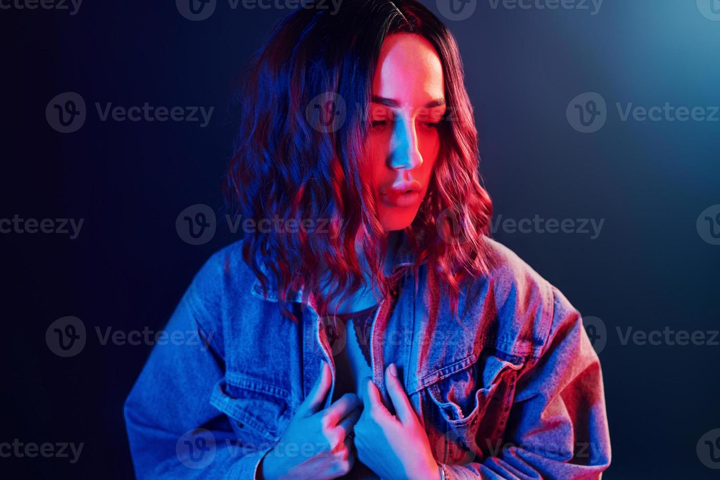 porträtt av ung flicka med lockigt hår i röd och blå neon i studio foto