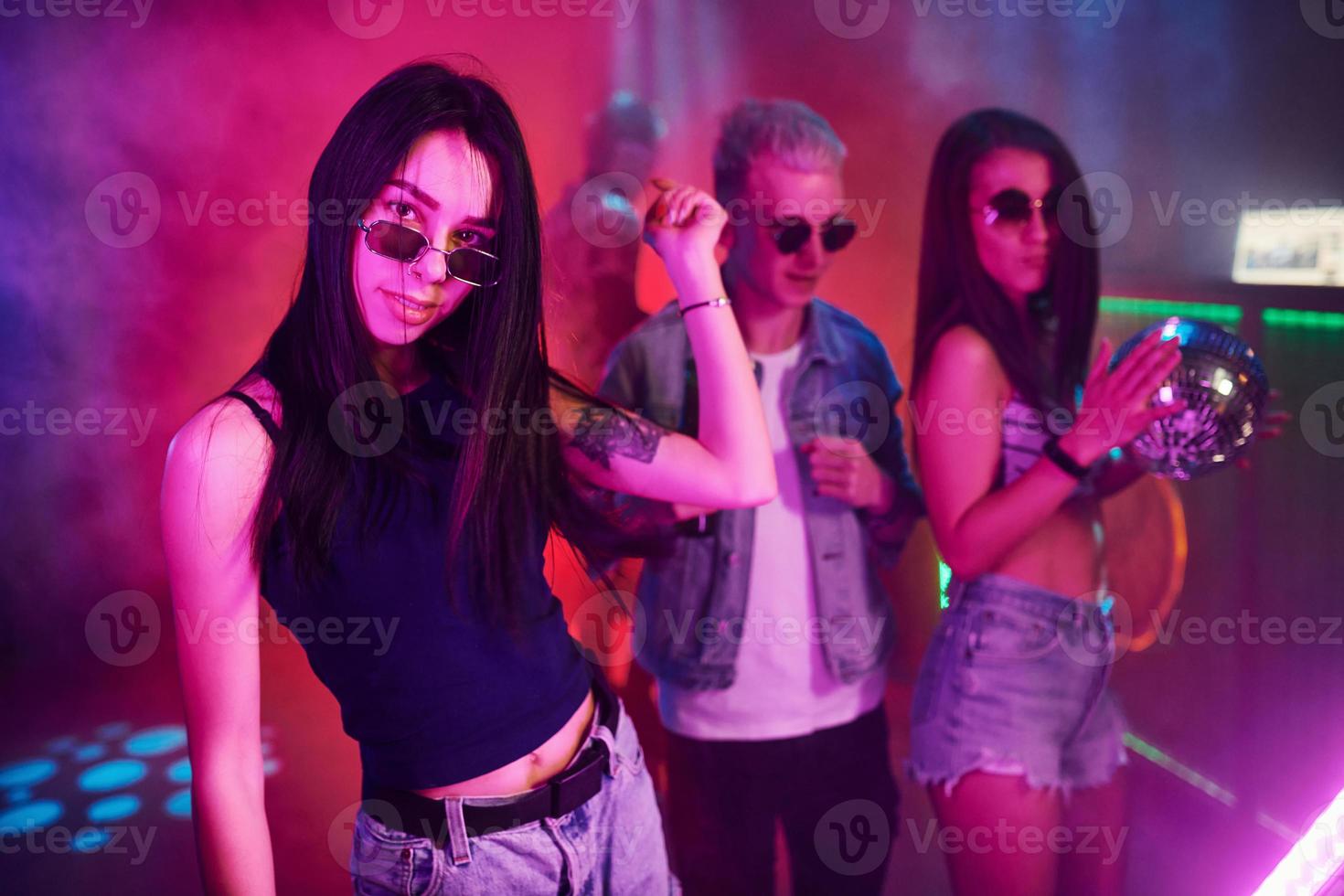 ung människor är har roligt i natt klubb med färgrik laser lampor foto