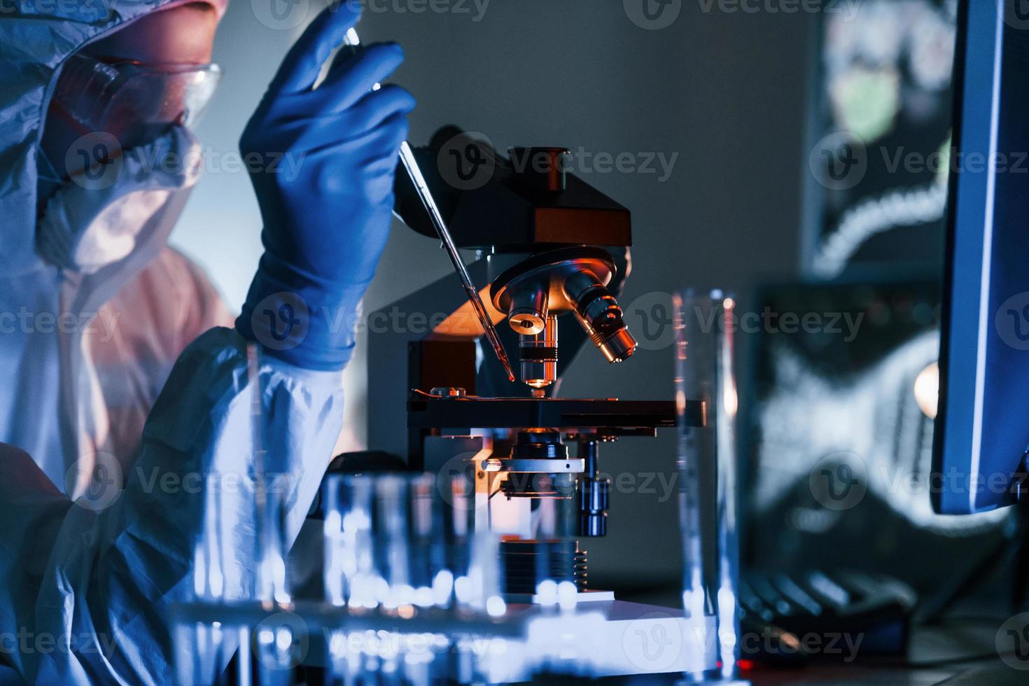 forskare i vit skyddande enhetlig Arbetar med coronavirus och blod rör i laboratorium foto