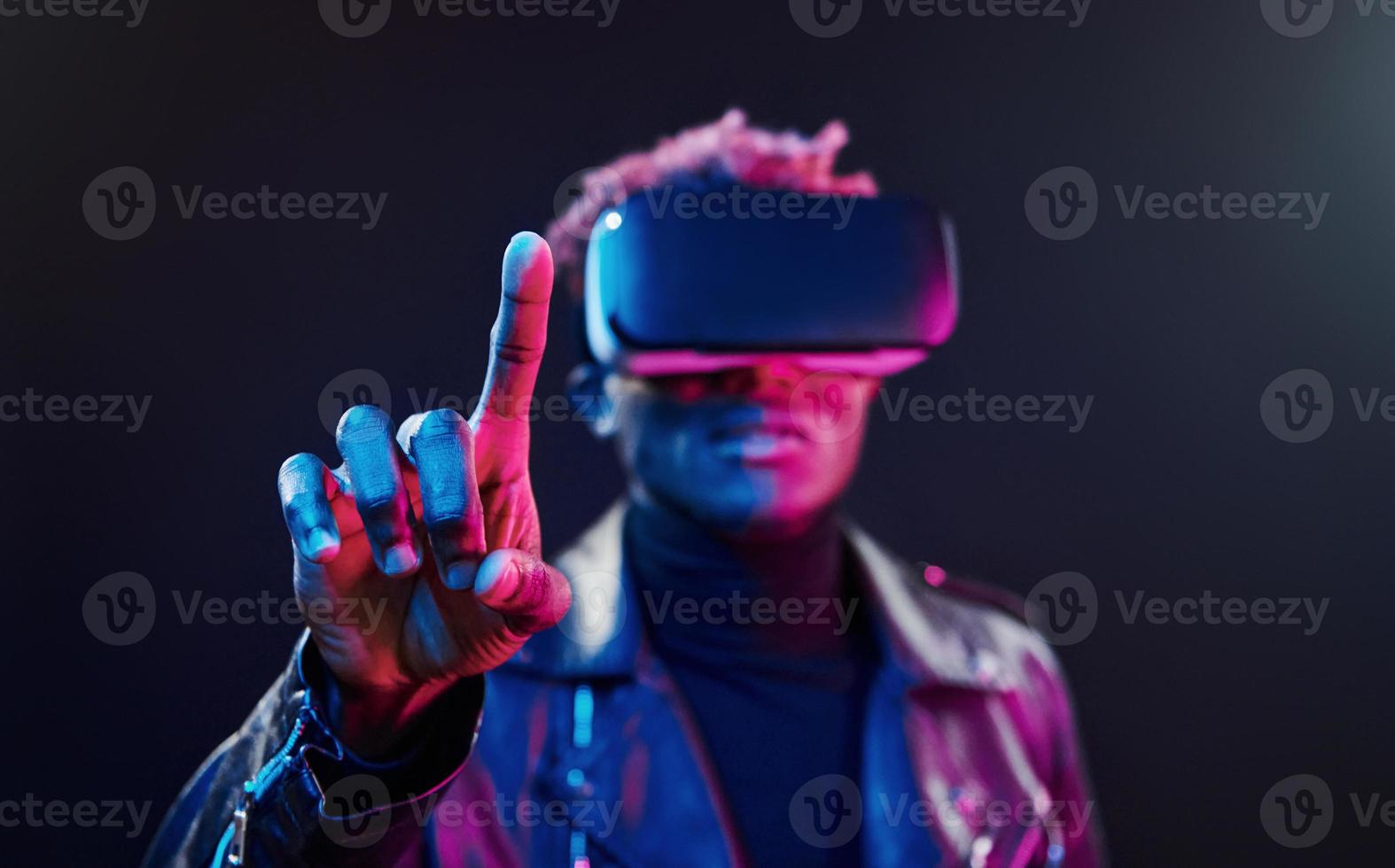 virtuell verklighet erfarenhet. trogen neon belysning. ung afrikansk amerikan man i de studio foto