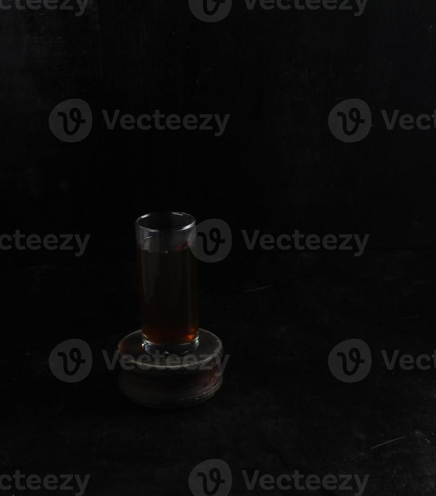 glas kopp av te på svart bakgrund foto