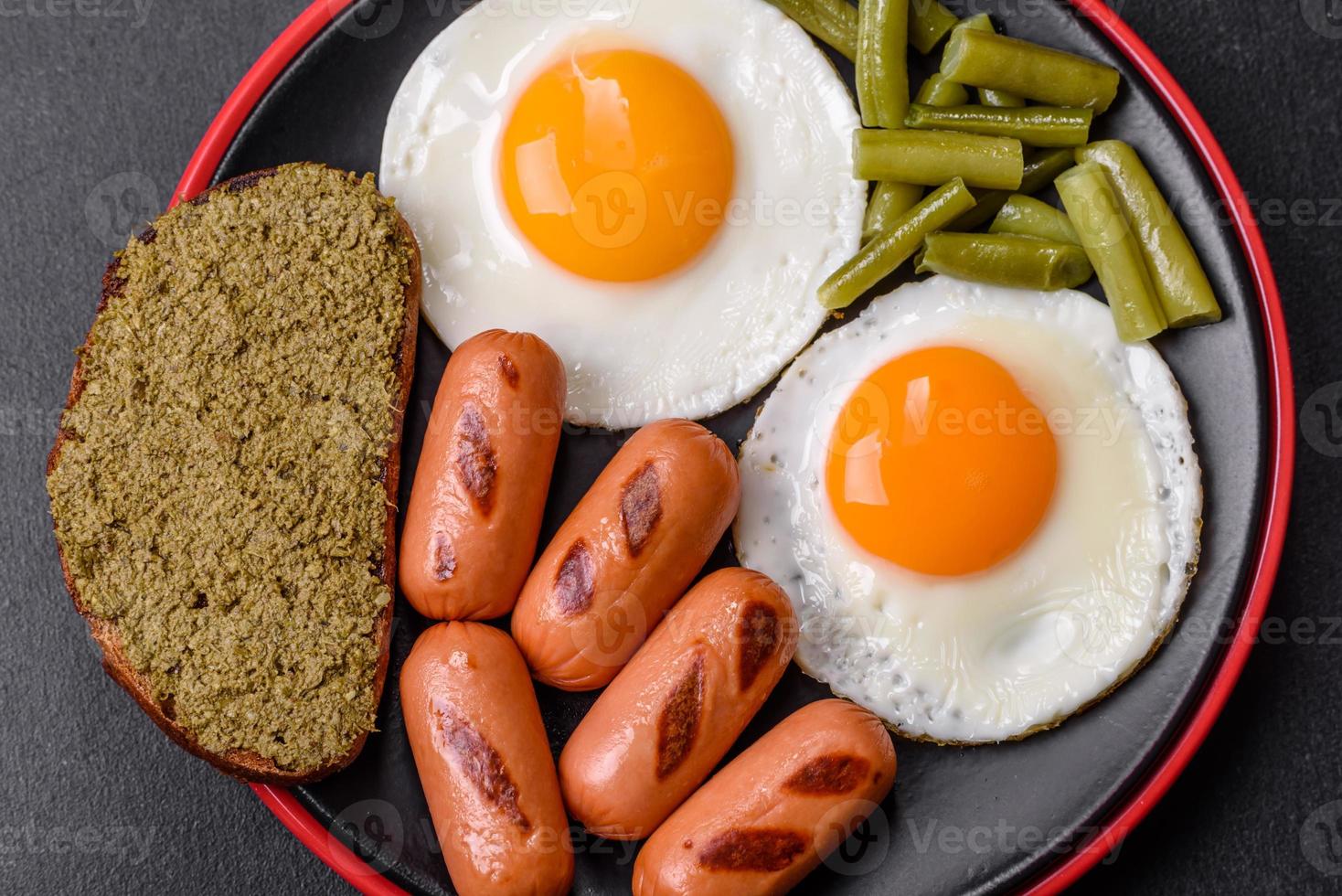 gott engelsk frukost av friterad ägg, bönor, sparris, korvar med kryddor och örter foto