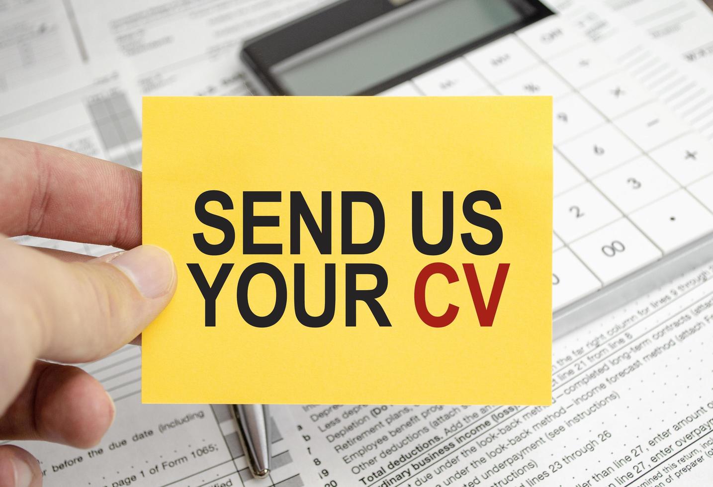 skicka oss din CV. text på gul klistermärke med kalkylator foto