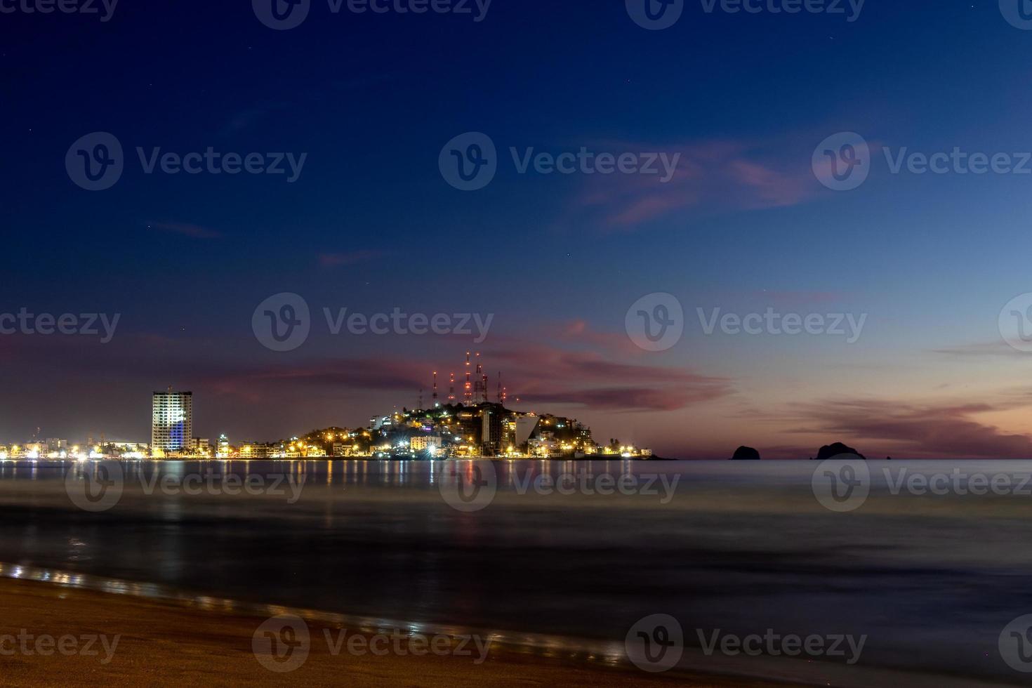 Mazatlan sinaloa strand på natt med lysande stad i de bakgrund foto