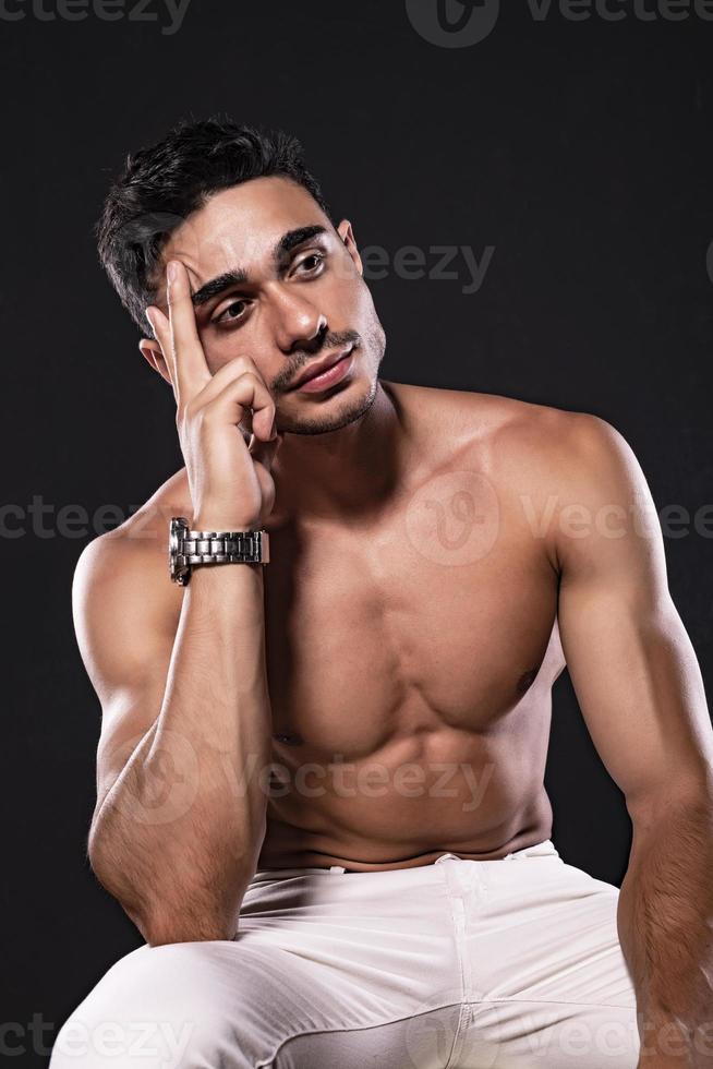 stilig arab manlig modell med perfekt kropp Framställ i studio. porträtt av en atletisk manlig modell Framställ på mörk bakgrund i de studio. mode begrepp. foto