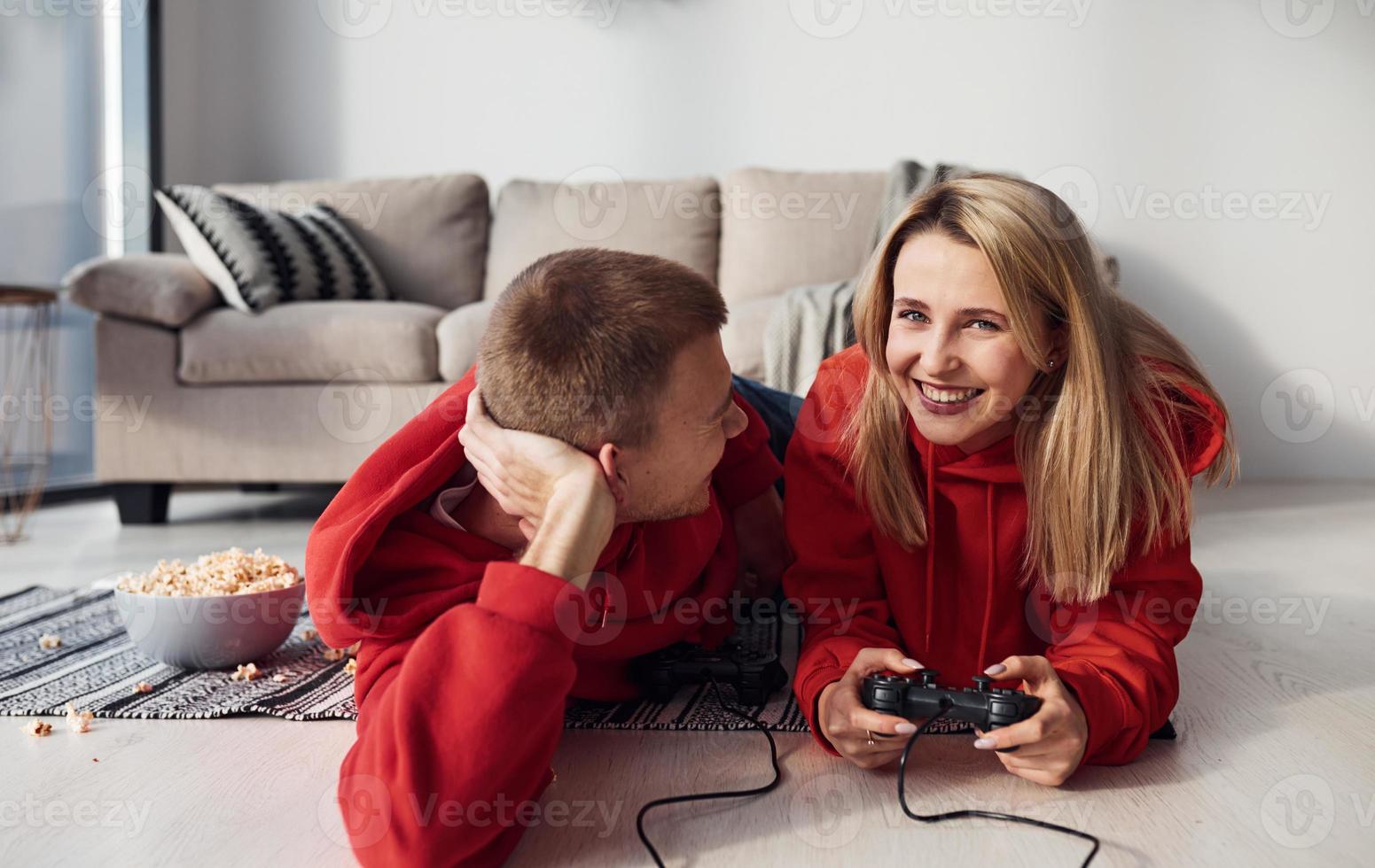 ung härlig par tillsammans på Hem spelar video spel på helgen och högtider tid tillsammans foto
