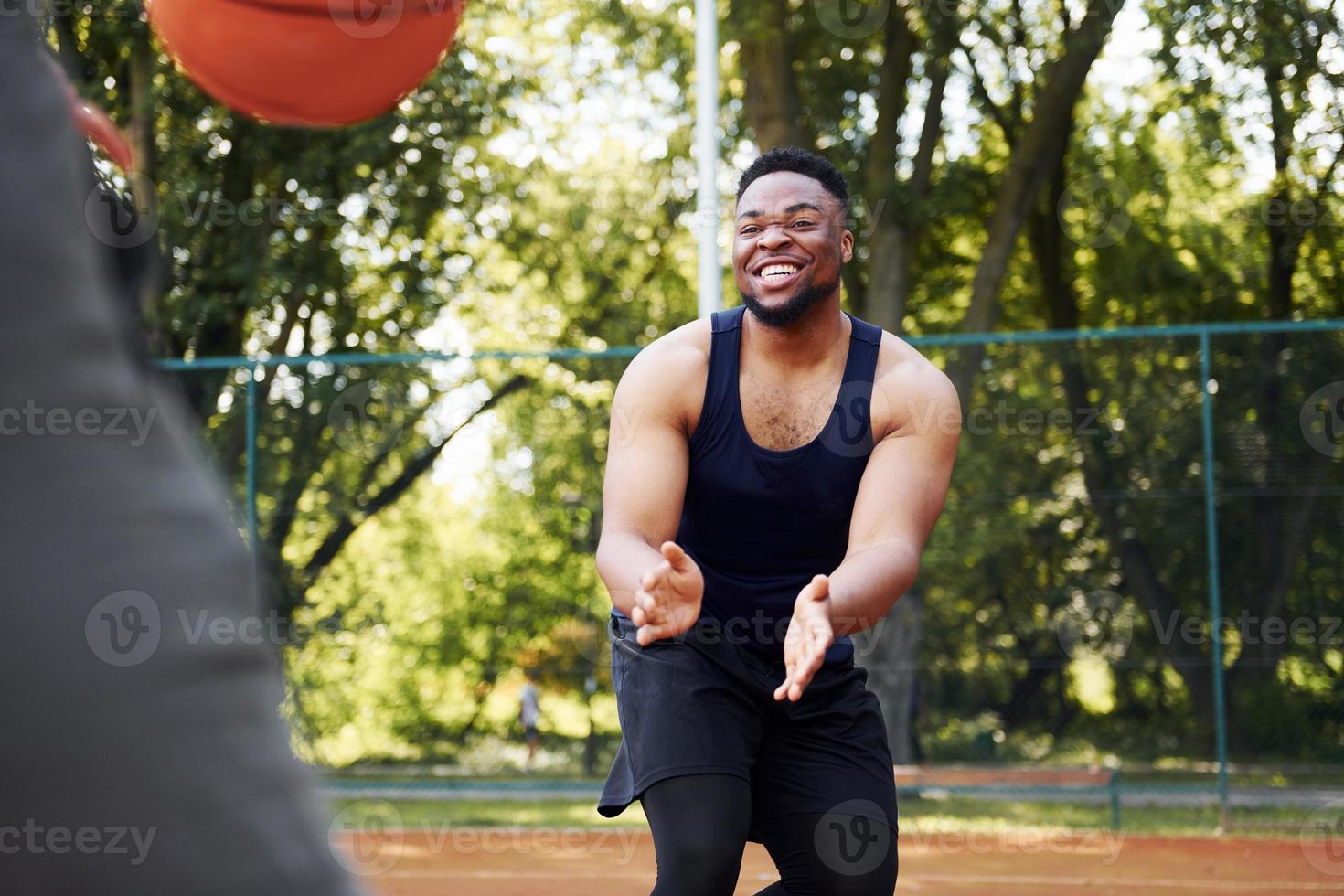 afrikansk amerikan man med flicka spelar basketboll på de domstol utomhus foto