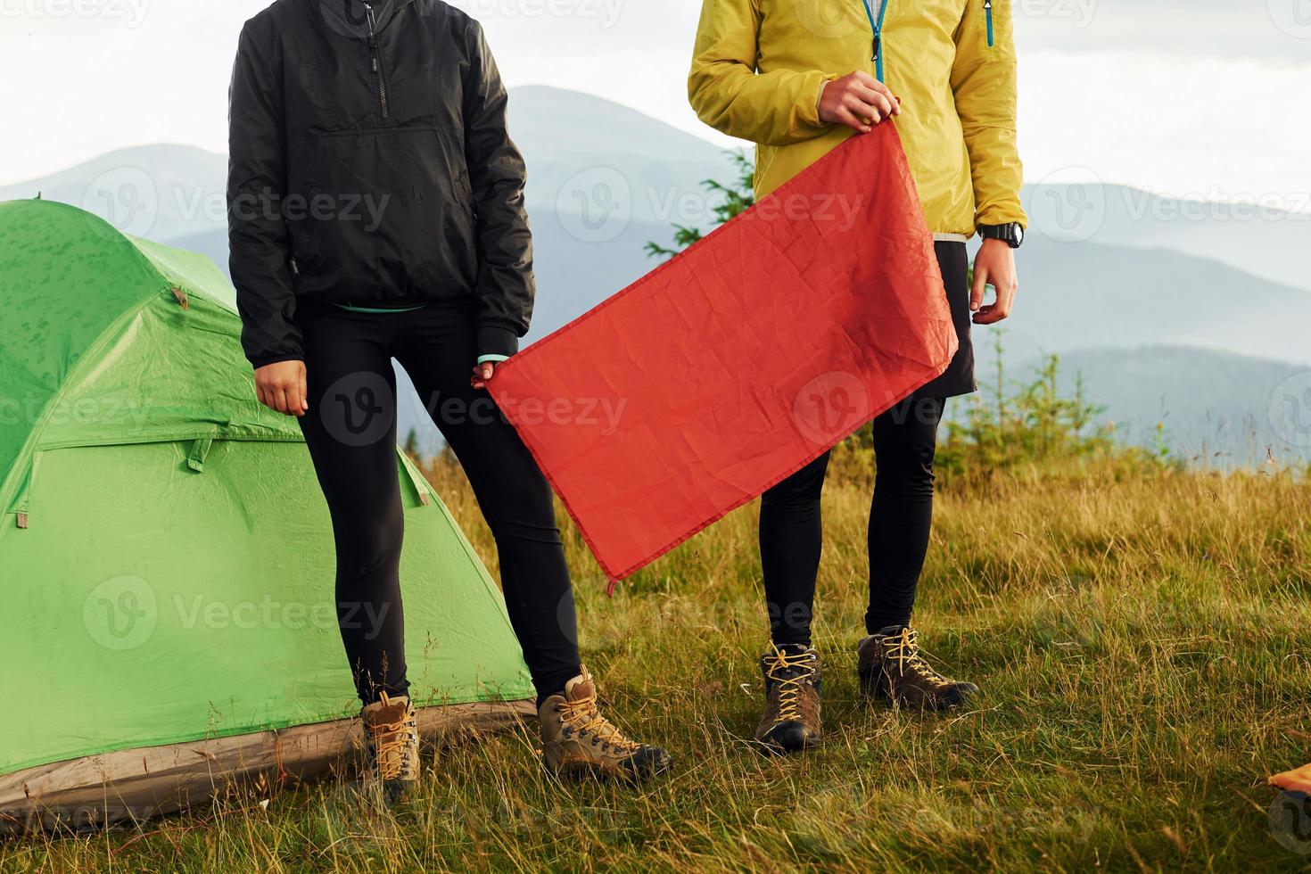 kvinna och man innehav röd flagga. majestätisk karpater berg. skön landskap av oberörd natur foto