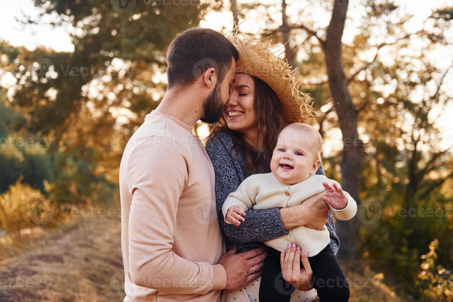 Lycklig familj av mor, familj och liten bebis vilar utomhus. skön solig höst natur foto