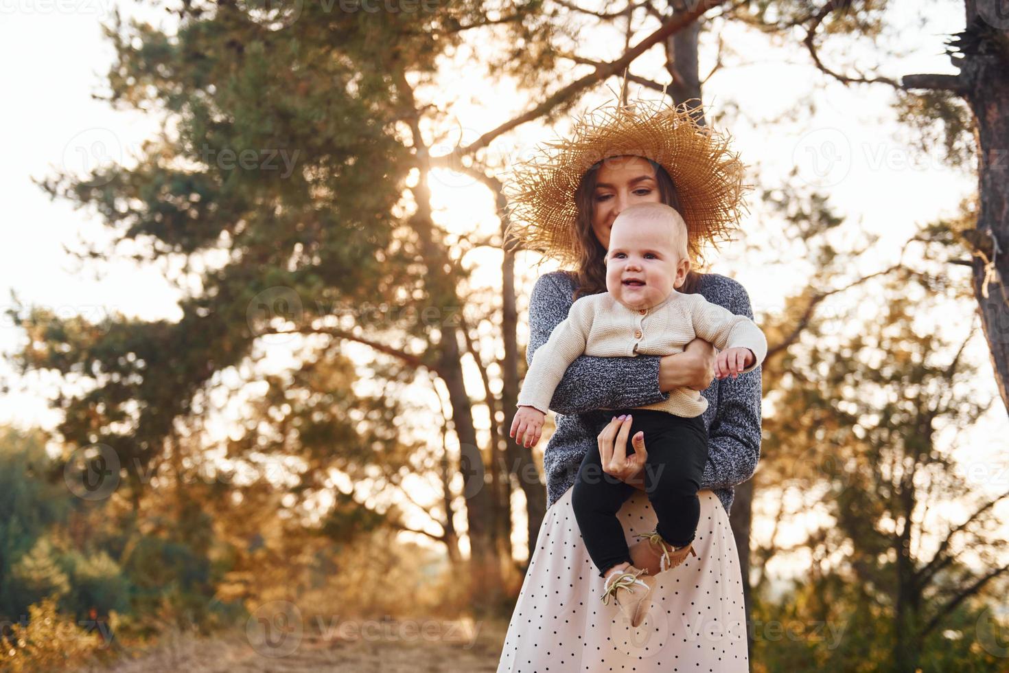 spelar tillsammans. ung mor med henne liten bebis vilar utomhus på höst säsong foto