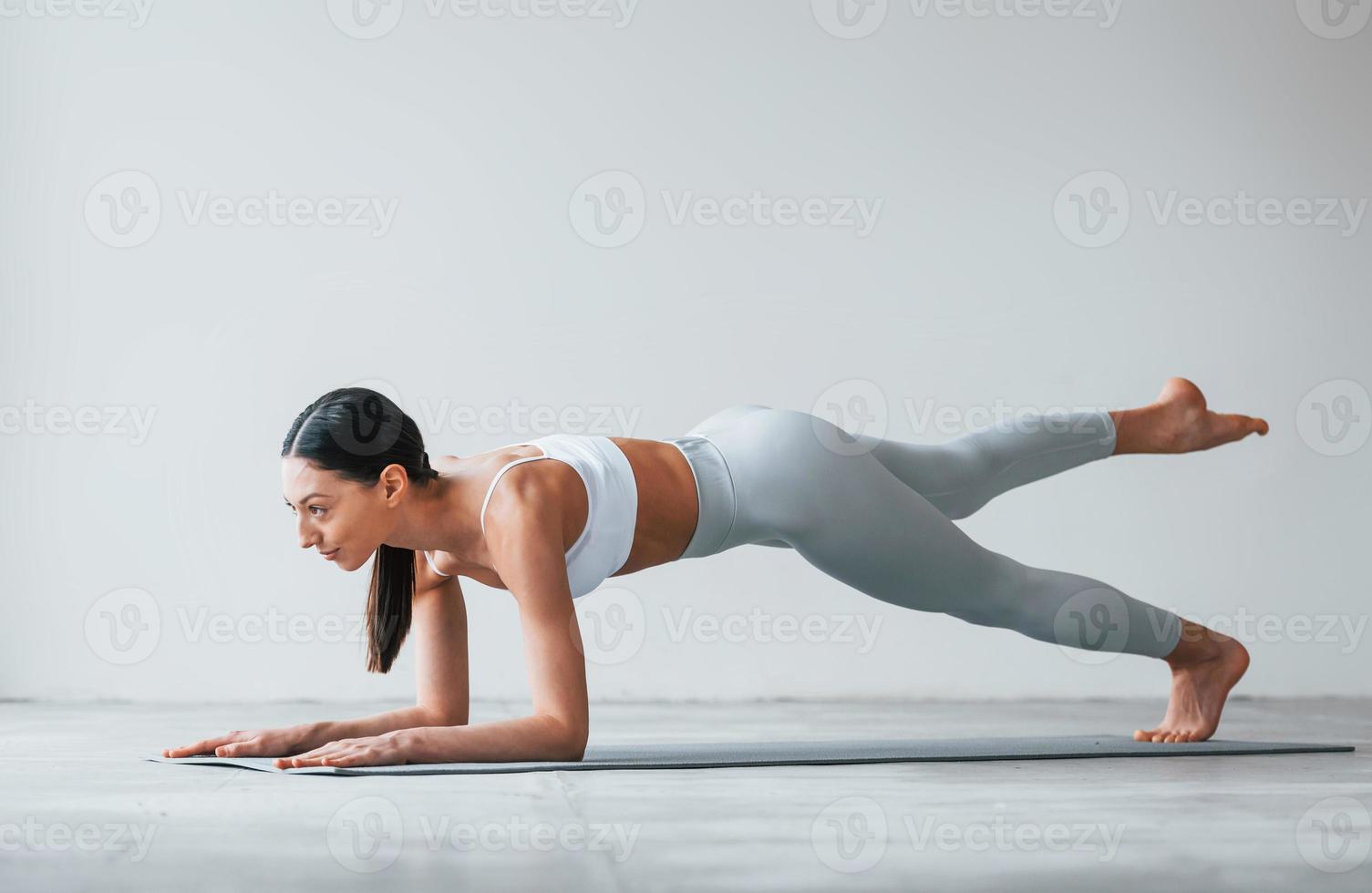 håller på med yoga övningar. kvinna med sportigt smal kropp typ i underkläder den där är i de studio foto