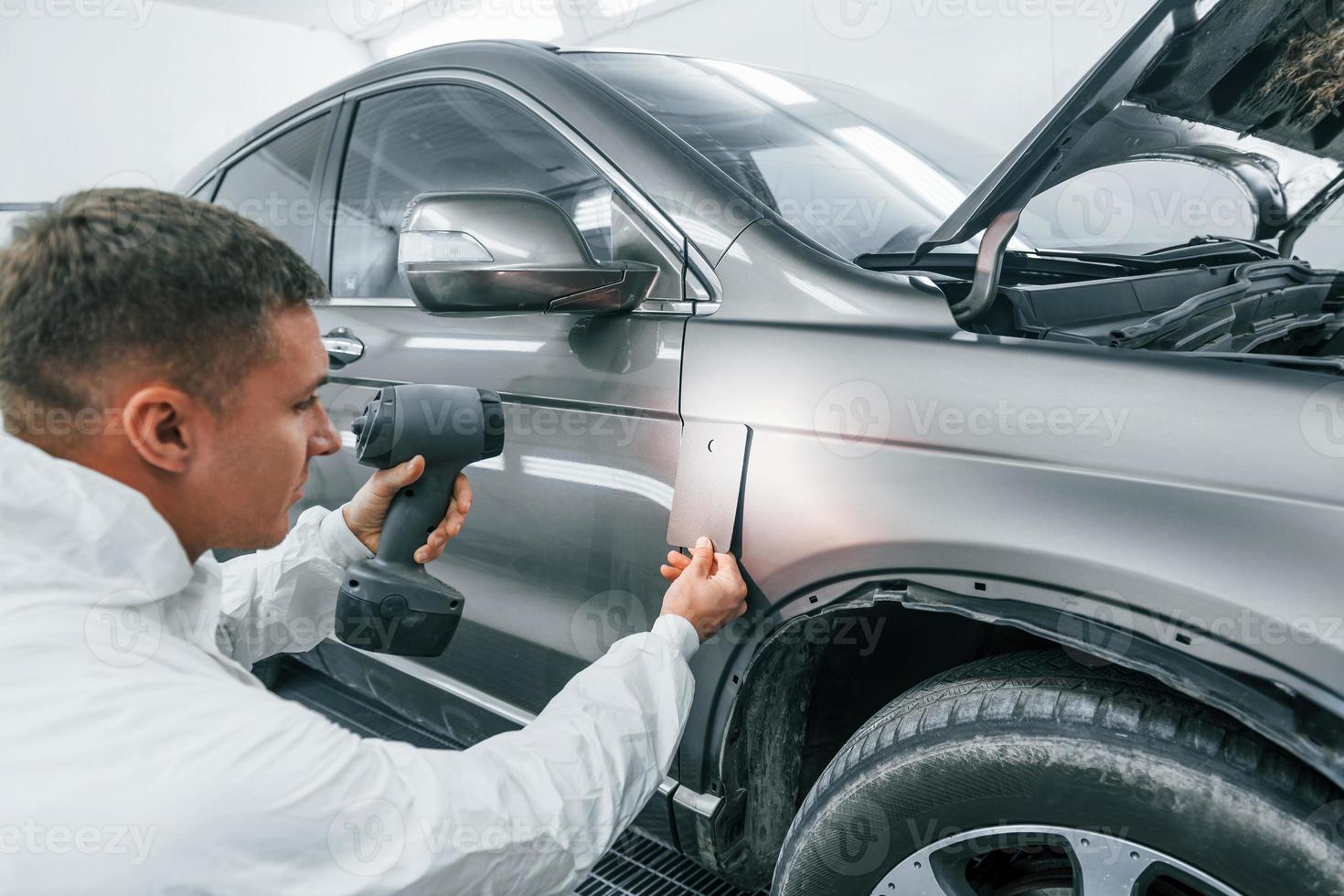 applicering ny Färg. caucasian bil reparatör i enhetlig Arbetar i garage foto