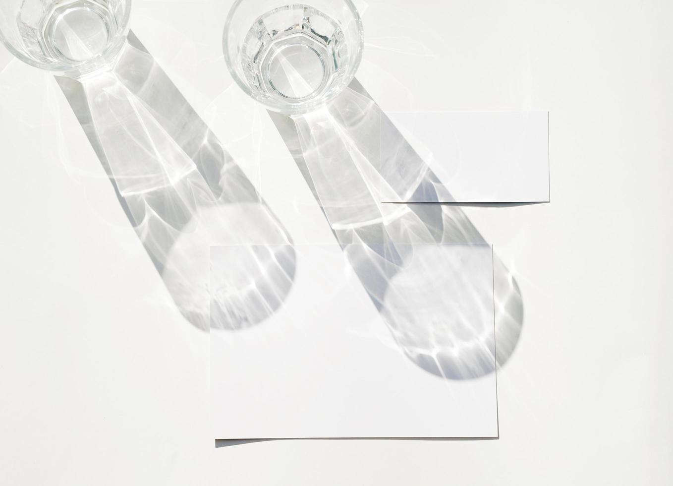 tom företag kort attrapp på glas med skugga av naturlig löv skugga täcka över på vit bakgrund, för produkt eller presentation foto