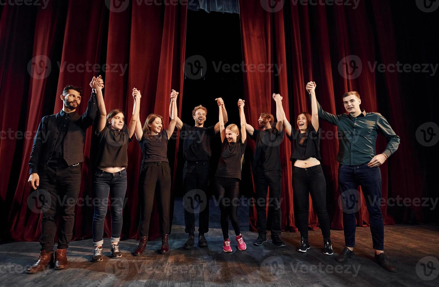 människor böjning till publik. grupp av aktörer i mörk färgad kläder på repetition i de teater foto