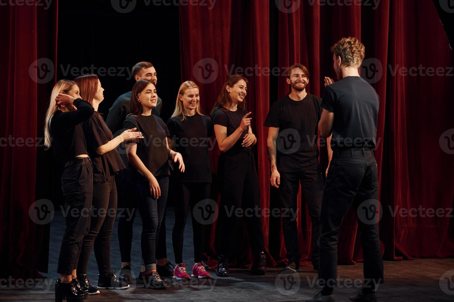 grupp av aktörer i mörk färgad kläder på repetition i de teater foto