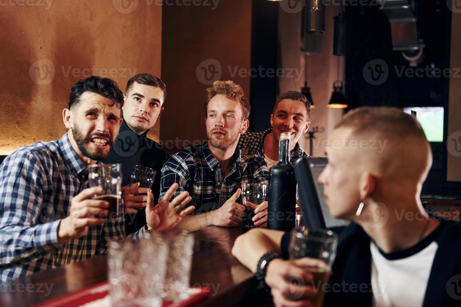 uttrycksfull människor tittar på fotboll. grupp av människor tillsammans inomhus i de pub ha roligt på helgen tid foto