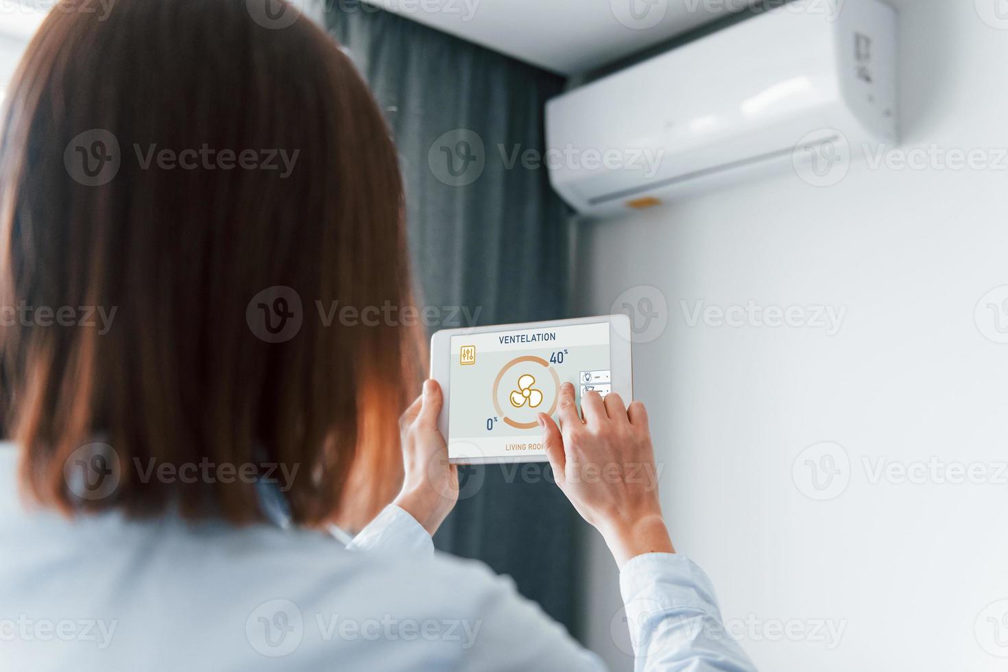 modern teknik. bak- se av kvinna den där är inomhus kontrollerande smart Hem foto