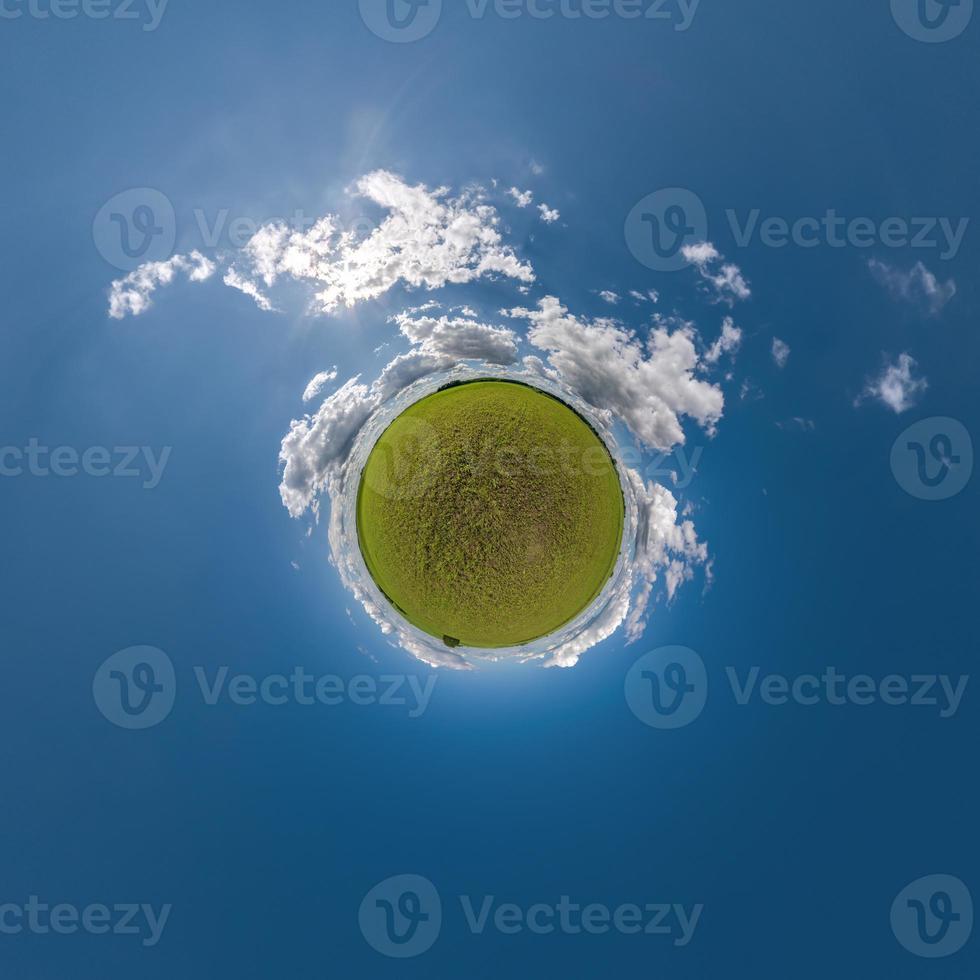grön mycket liten planet i blå himmel med skön moln med omvandling av sfärisk panorama 360 grader. krökning av Plats. foto