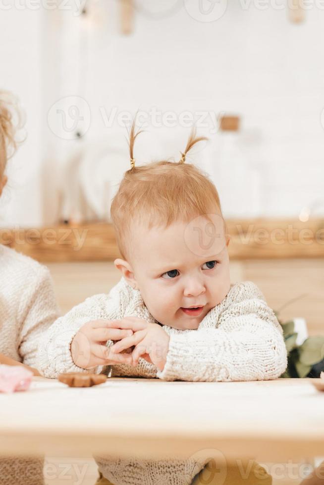 liten flicka med två hästsvansar visar rolig ansikten med ilska foto