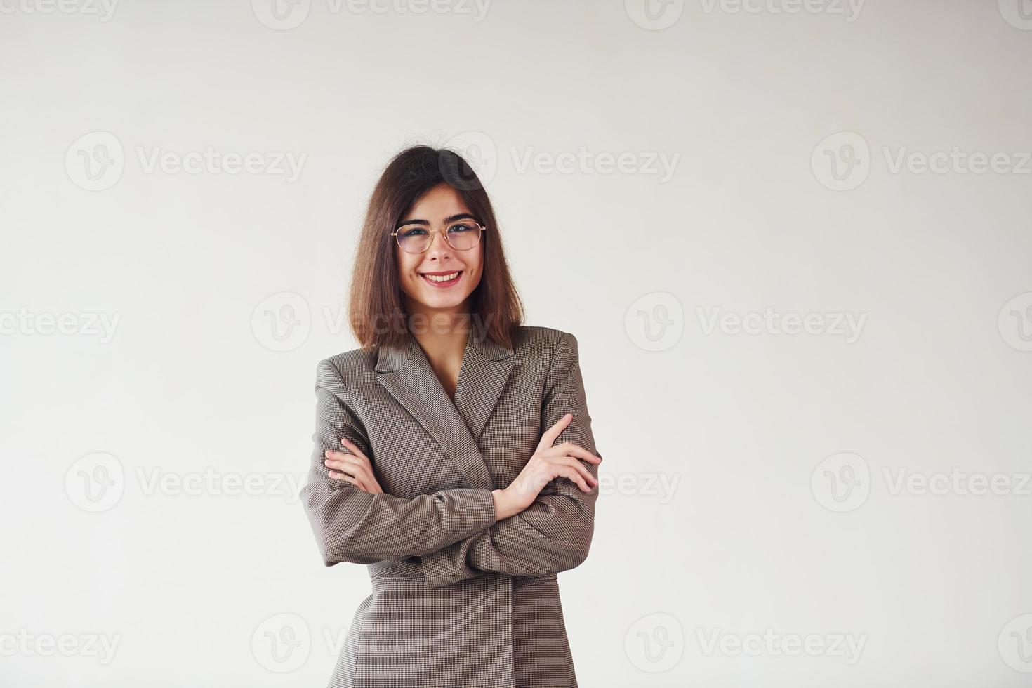 ung kvinna i formell kläder är stående mot vit bakgrund i de studio foto