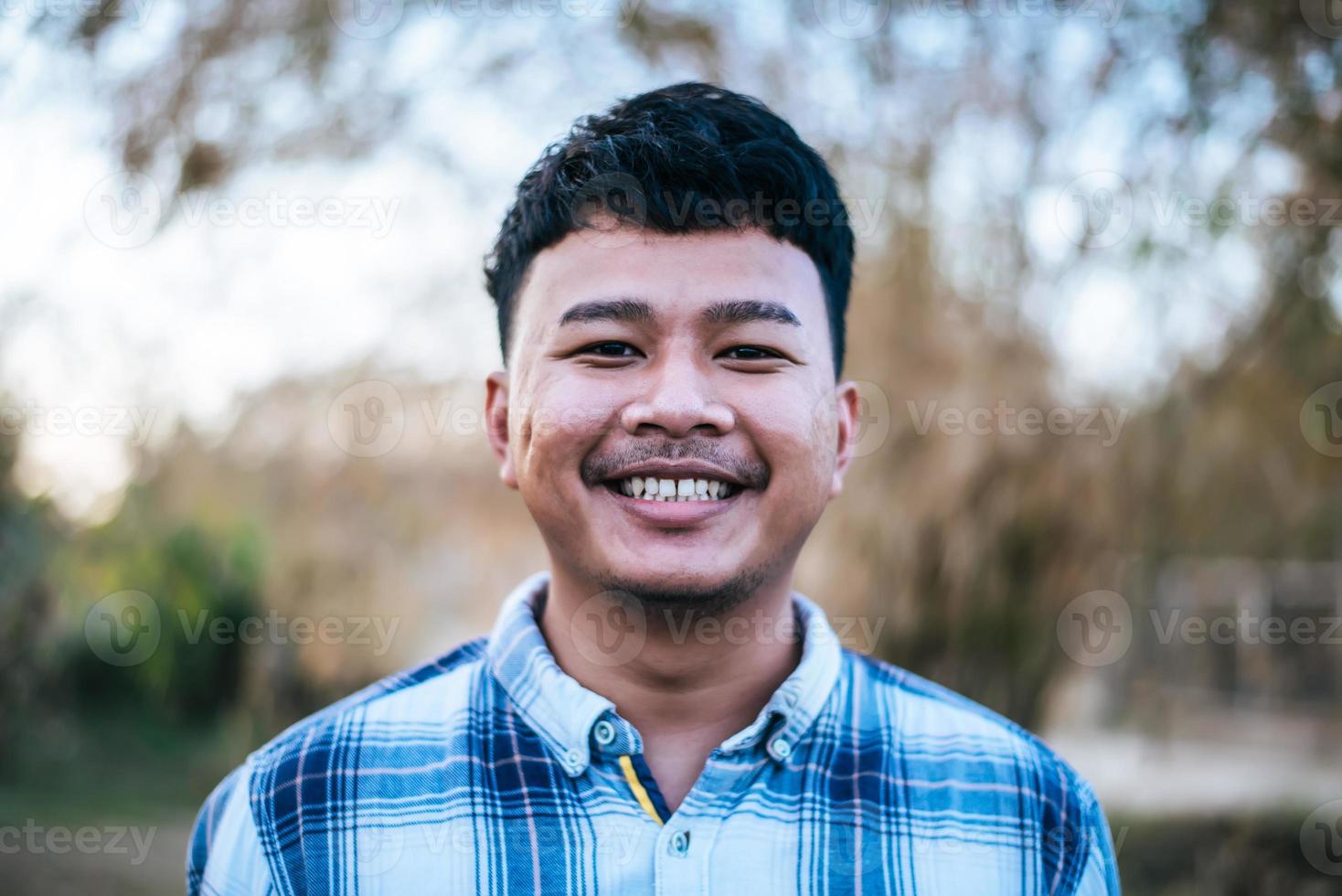 porträtt asiatisk ung man leende med Lycklig foto