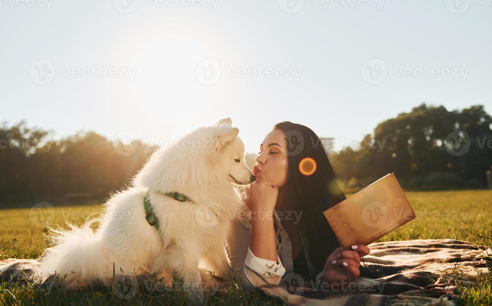 kvinna med henne hund är har roligt på de fält på solig dagtid foto