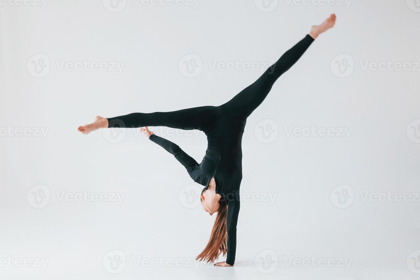 professionell övningar. ung kvinna i sportigt kläder håller på med gymnastik inomhus foto