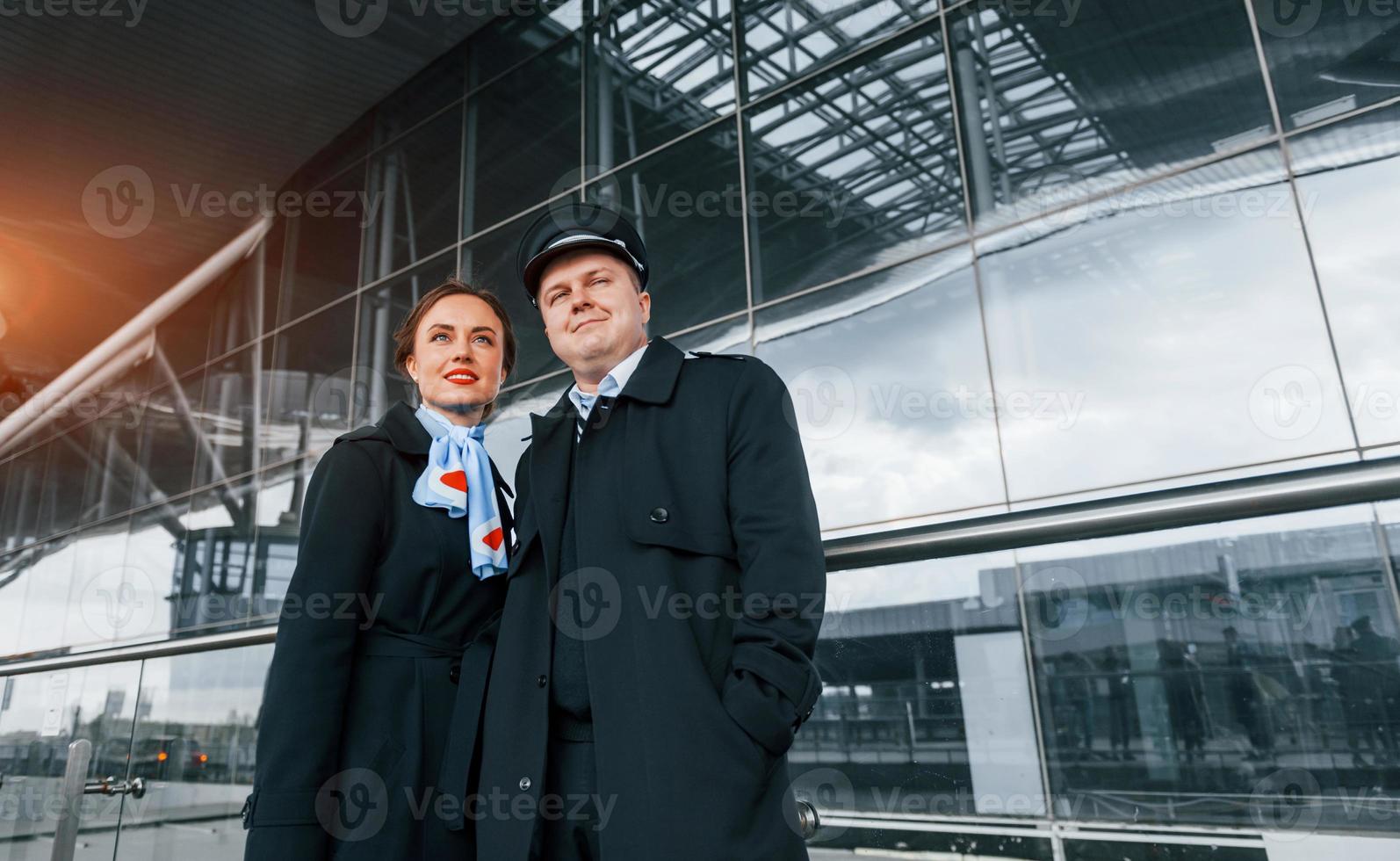man med kvinna. flygplan besättning i arbete enhetlig är tillsammans utomhus i de flygplats foto