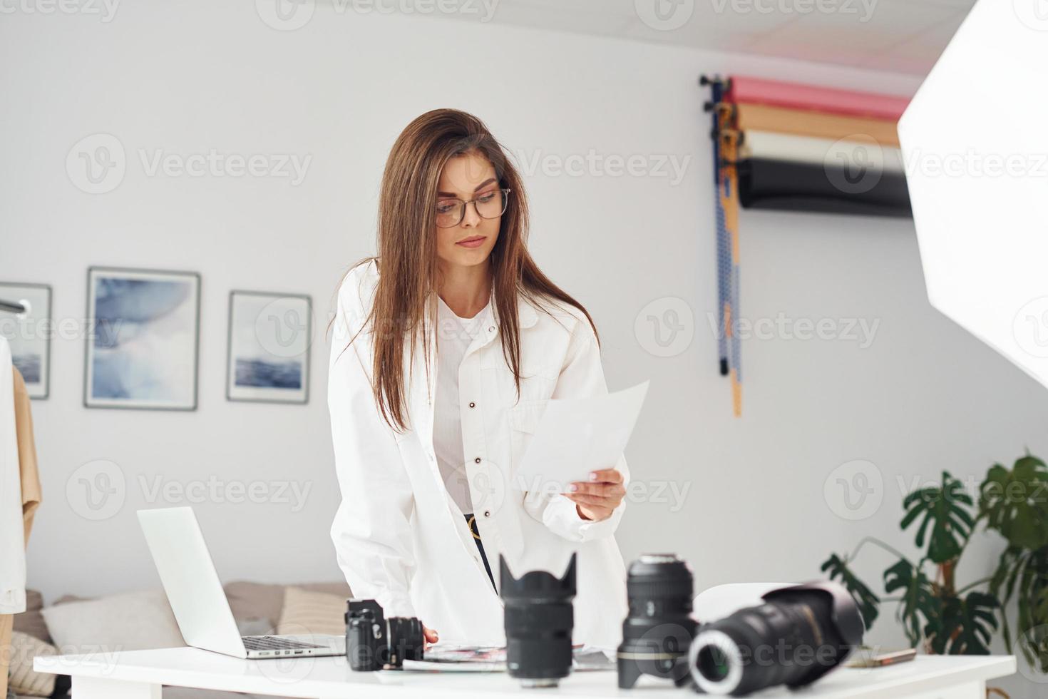 kvinna fotograf i tillfällig kläder är arbetssätt inomhus på dagtid foto