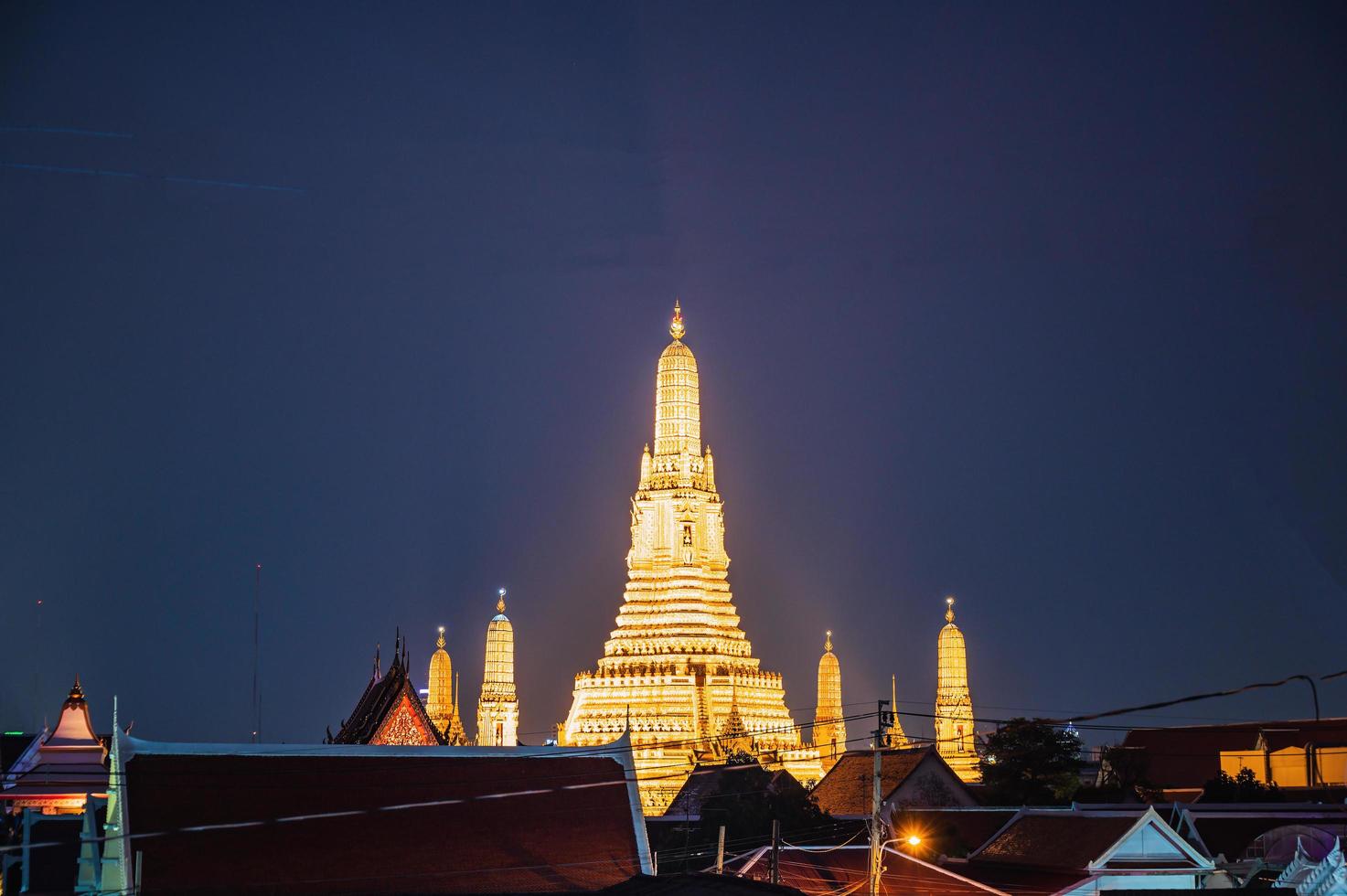 wat en springtur med tak topp av de byggnad i de natt tid.wat en springtur ratchawararam ratchawaramahawihan eller wat en springtur är en buddist tempel i bangkok yai distrikt av bangkok foto