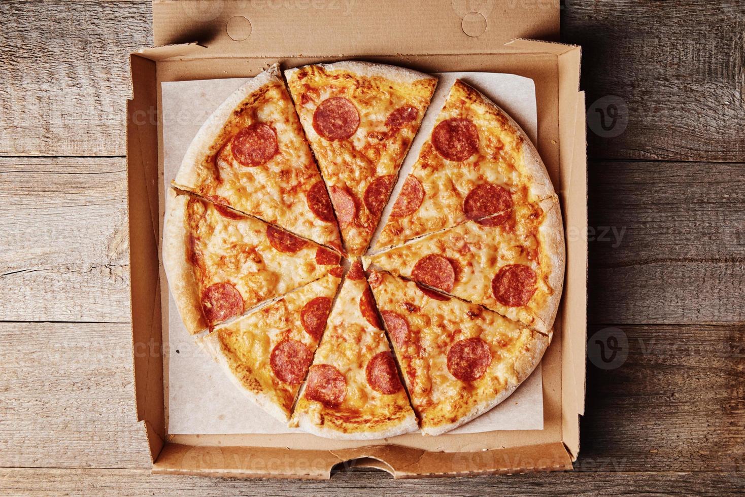 skiva av pizza i kartong låda, närbild foto