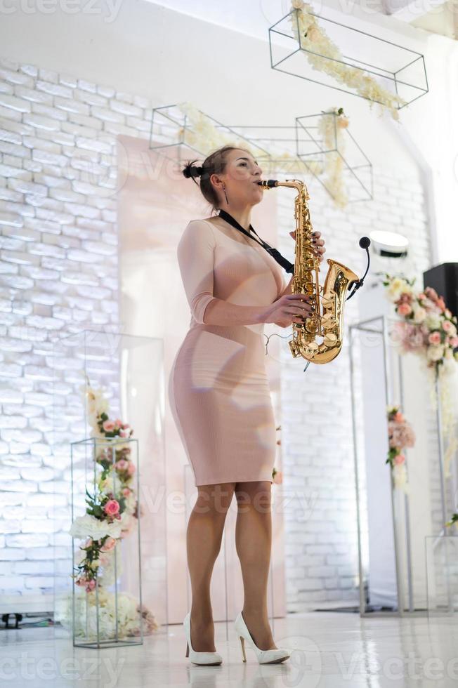 skön flicka spelar saxofon foto